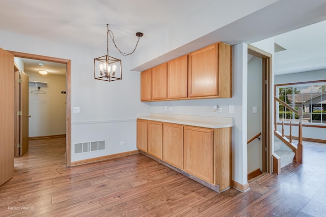 2675 Dorothy Dr, Aurora, IL 60504 - kitchen featuring light wood finished floors, baseboards, a chandelier, light countertops, and pendant lighting