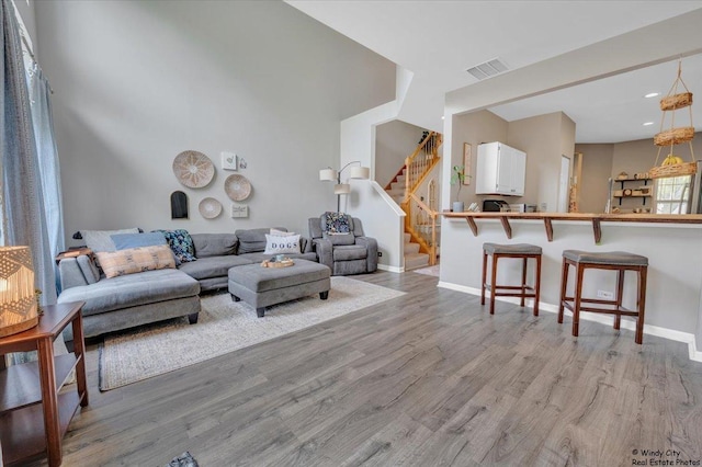 living area featuring light wood finished floors, stairs, baseboards, and recessed lighting