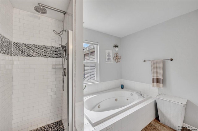 bathroom with a shower stall and a jetted tub