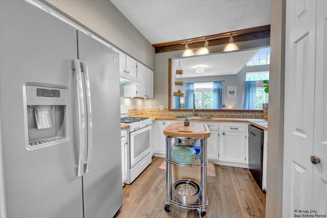 kitchen featuring fridge with ice dispenser, white gas range oven, a sink, dishwasher, and white cabinetry