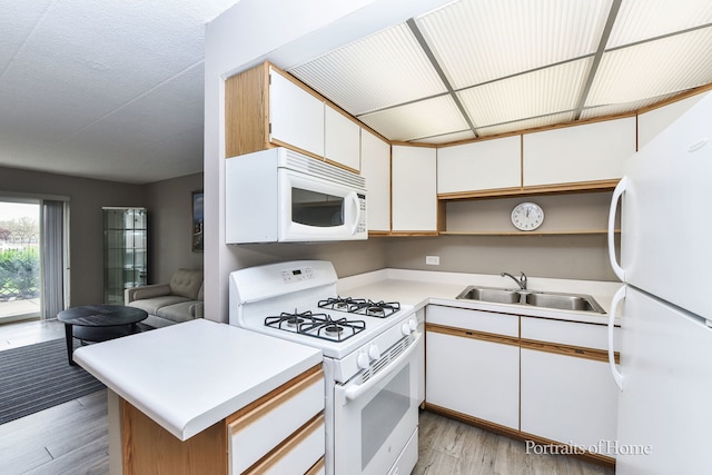 kitchen with white appliances, a sink, light wood-style floors, light countertops, and open shelves