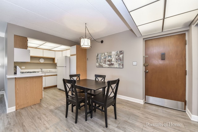 dining room with light wood-type flooring and baseboards