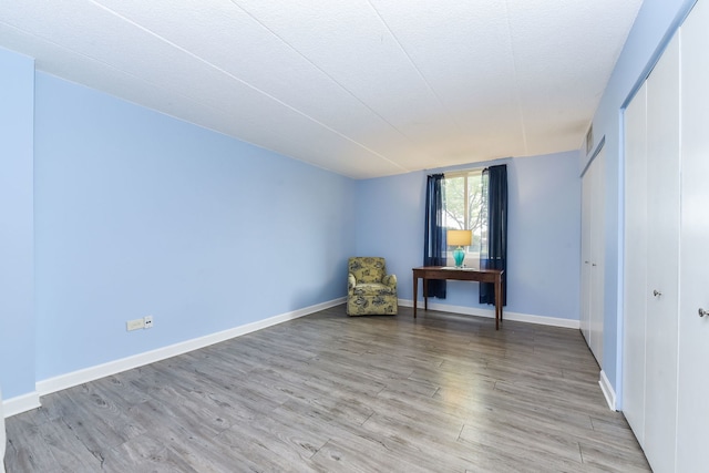 unfurnished room featuring light wood-style floors and baseboards