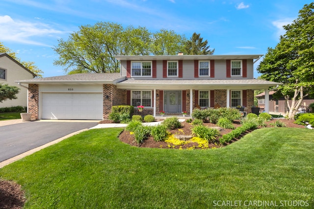 833 Shiloh Cir, Naperville, IL 60540 - traditional-style home featuring an attached garage, asphalt driveway, brick siding, a front lawn, and covered porch