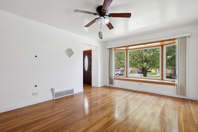 empty room with light wood-type flooring, baseboards, and ceiling fan