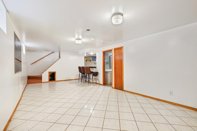 living room featuring stairway, bar, and baseboards