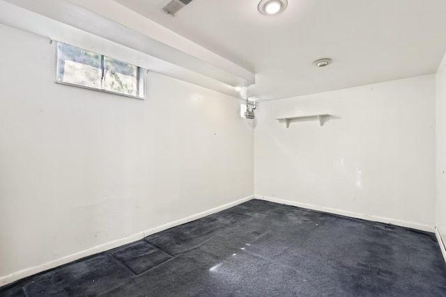 basement with baseboards and dark colored carpet
