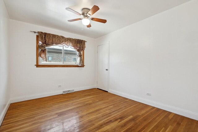spare room with wood finished floors, baseboards, and ceiling fan