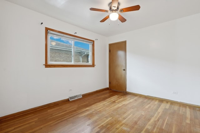 empty room featuring light wood-type flooring, baseboards, and a ceiling fan