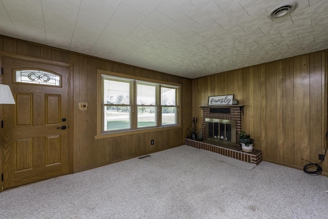 6305 247th Ave, Paddock Lake, WI 53168 - unfurnished living room with carpet, wood walls, a brick fireplace, and baseboards