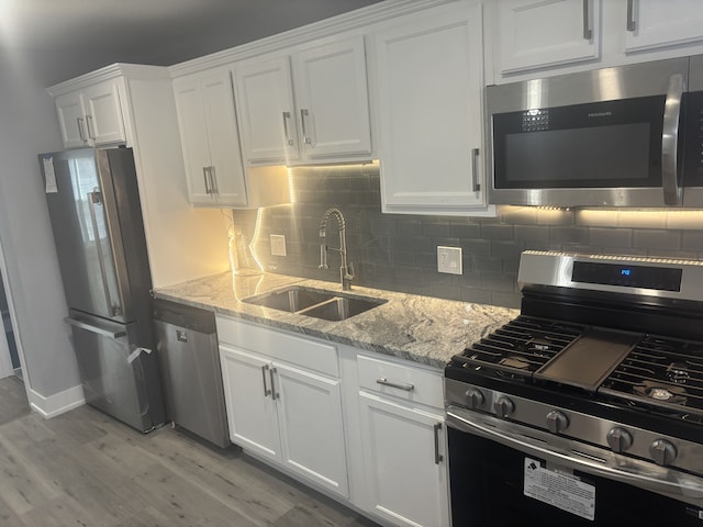 603 N Long Ave, Chicago, IL 60644 - kitchen featuring appliances with stainless steel finishes, a sink, white cabinetry, and decorative backsplash