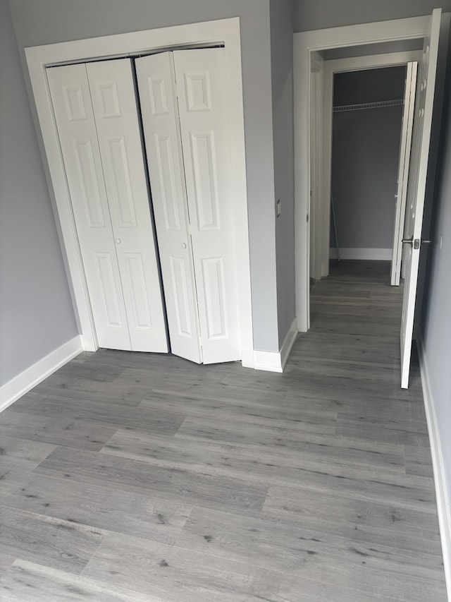 603 N Long Ave, Chicago, IL 60644 - unfurnished bedroom featuring baseboards, a closet, and wood finished floors
