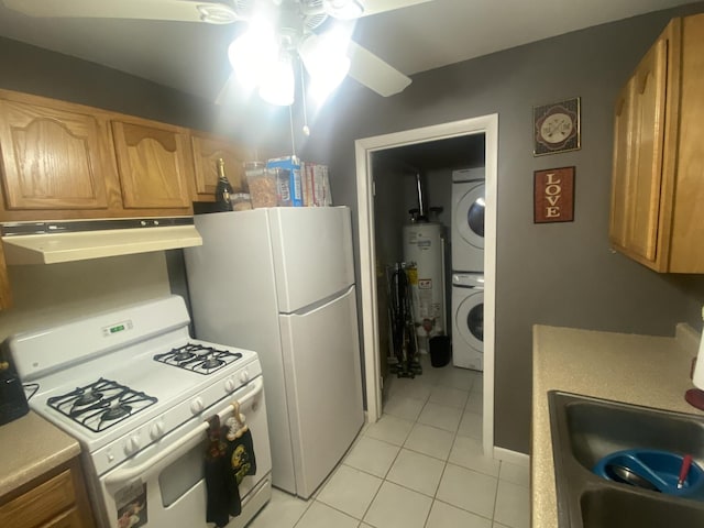 kitchen with stacked washing machine and dryer, white appliances, range hood, light tile patterned floors, and water heater