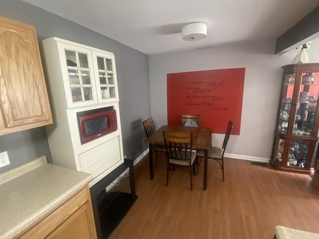 dining room featuring wood finished floors and baseboards