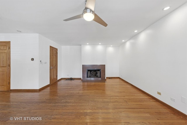 3913 N Kedvale Ave Unit A, Chicago, IL 60641 - unfurnished living room with ceiling fan, a tiled fireplace, wood finished floors, baseboards, and recessed lighting