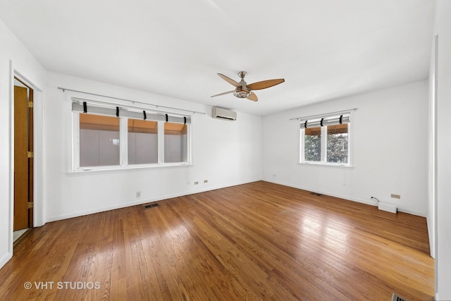 3913 N Kedvale Ave Unit A, Chicago, IL 60641 - unfurnished room with a wall mounted air conditioner, ceiling fan, wood finished floors, and baseboards
