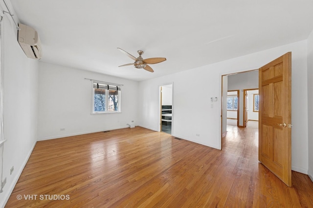 3913 N Kedvale Ave Unit A, Chicago, IL 60641 - unfurnished room featuring a wall mounted air conditioner, a ceiling fan, light wood finished floors, and baseboards