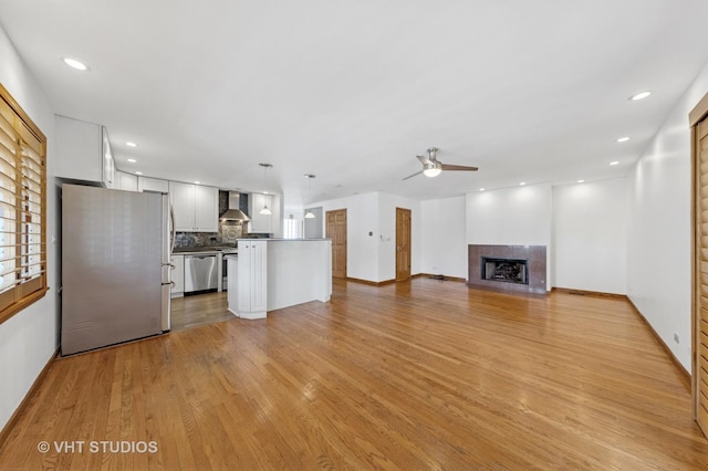 3913 N Kedvale Ave Unit A, Chicago, IL 60641 - unfurnished living room with ceiling fan, light wood finished floors, a tile fireplace, baseboards, and recessed lighting
