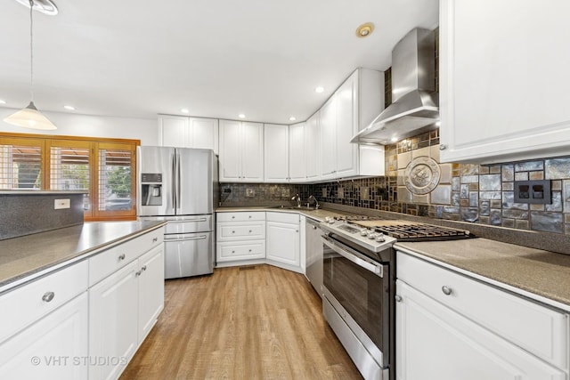 3913 N Kedvale Ave Unit A, Chicago, IL 60641 - kitchen with stainless steel appliances, wall chimney range hood, a sink, white cabinetry, and decorative backsplash