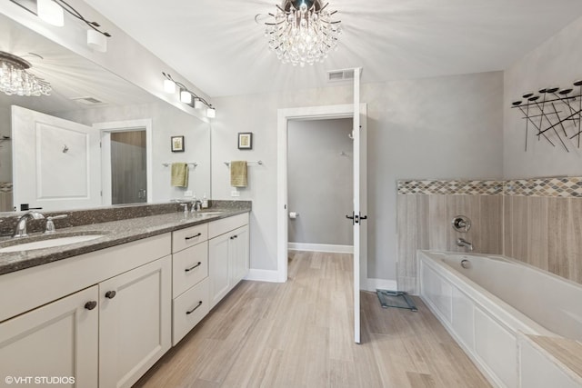 149 W Kennedy Ln Unit 208, Hinsdale, IL 60521 - bathroom with a chandelier, double vanity, a garden tub, and wood finished floors