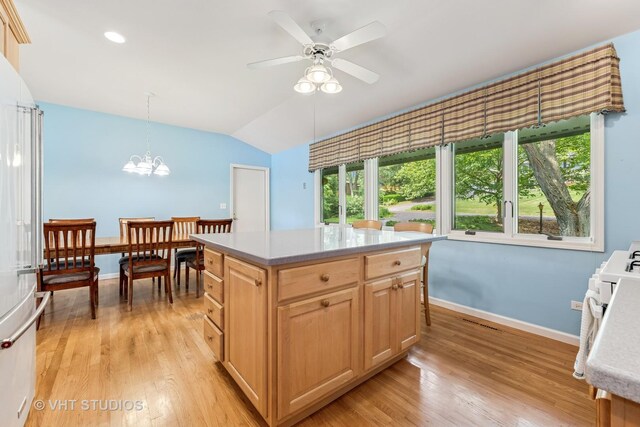 907 Division St, Barrington, IL 60010 - kitchen featuring light wood-type flooring, vaulted ceiling, light brown cabinetry, light countertops, and decorative light fixtures