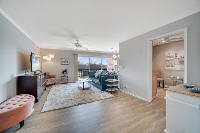 living room featuring a ceiling fan, ornamental molding, light wood-type flooring, and baseboards