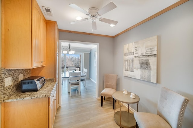 living area featuring light wood-style floors, crown molding, ceiling fan, and baseboards