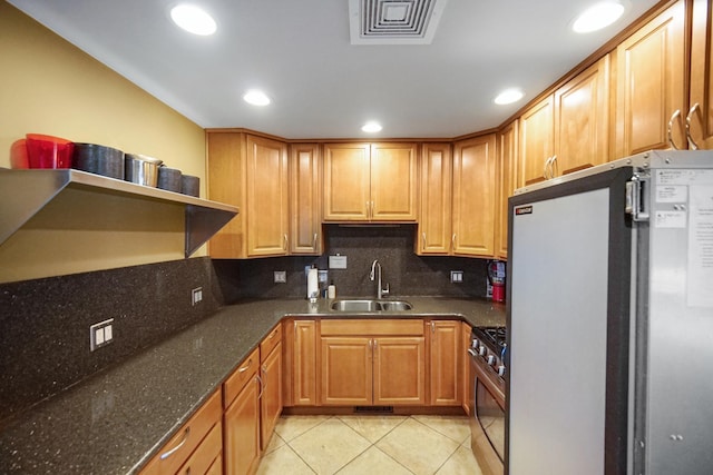 kitchen with a sink, refrigerator, stainless steel range with gas stovetop, open shelves, and light tile patterned floors