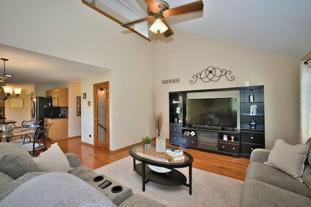 1729 Hidden Oaks Ct, Plainfield, IL 60586 - living area featuring light wood-style floors, a ceiling fan, high vaulted ceiling, and a chandelier