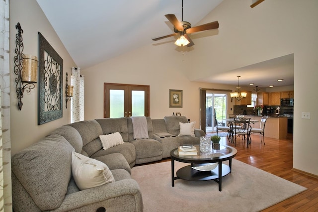 1729 Hidden Oaks Ct, Plainfield, IL 60586 - living room featuring light wood finished floors, a chandelier, a ceiling fan, french doors, and high vaulted ceiling