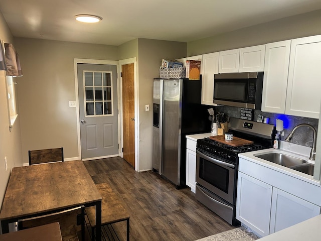 210 E Edgelawn Dr, Plano, IL 60545 - kitchen featuring appliances with stainless steel finishes, a sink, dark wood-style floors, white cabinets, and light countertops