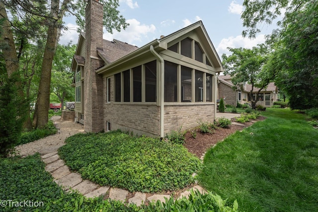 2325 Durand Dr, Downers Grove, IL 60515 - view of property exterior with a chimney, a lawn, a sunroom, roof with shingles, and stone siding