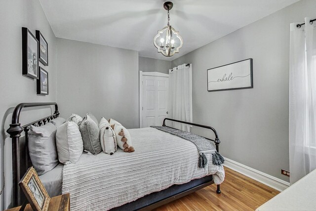 2742 N 76th Ct, Elmwood Park, IL 60707 - bedroom with a chandelier, baseboards, and wood finished floors