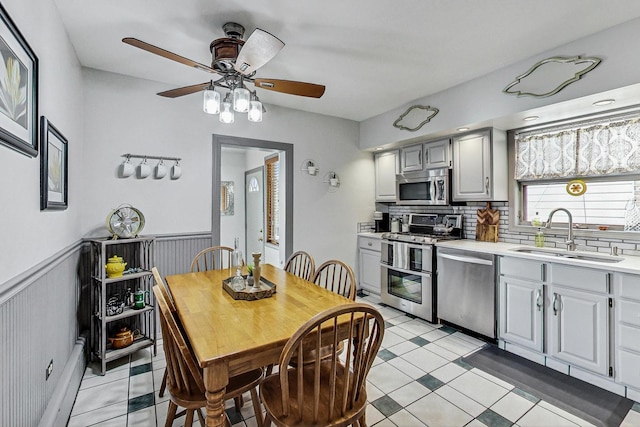 2742 N 76th Ct, Elmwood Park, IL 60707 - kitchen featuring a sink, stainless steel appliances, light countertops, decorative backsplash, and a ceiling fan