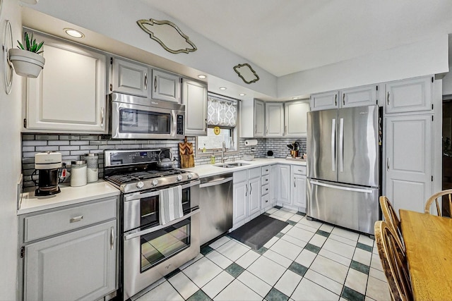 2742 N 76th Ct, Elmwood Park, IL 60707 - kitchen featuring appliances with stainless steel finishes, a sink, light countertops, decorative backsplash, and gray cabinets