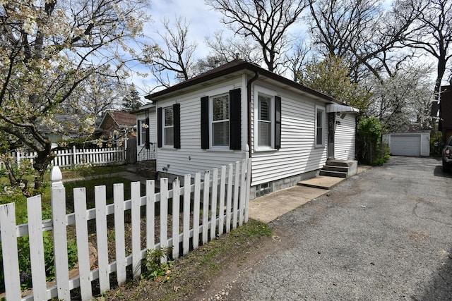 313 N Jackson St, Waukegan, IL 60085 - view of front of home with asphalt driveway, fence, an outdoor structure, and a garage