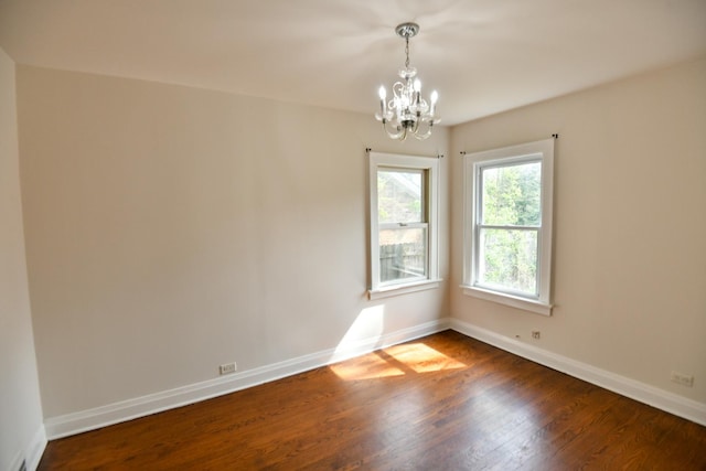 313 N Jackson St, Waukegan, IL 60085 - unfurnished room featuring a chandelier, dark wood-style flooring, and baseboards