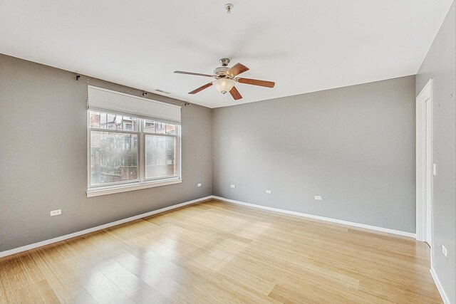 spare room featuring ceiling fan, light wood-style floors, baseboards, and fire sprinkler in ceiling