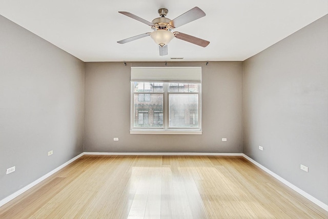 empty room featuring light wood-type flooring, baseboards, and a ceiling fan