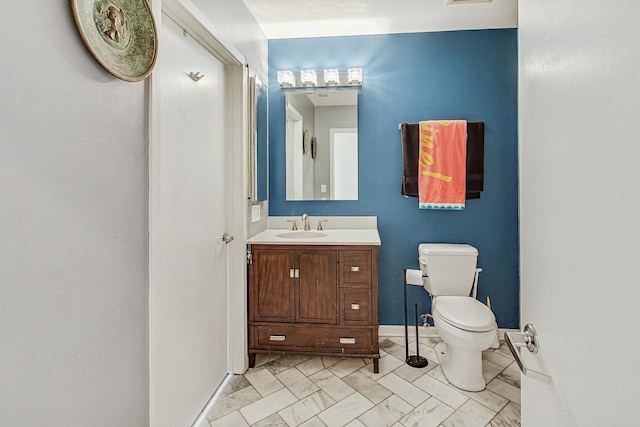 half bathroom featuring toilet, marble look tiles, vanity, and baseboards