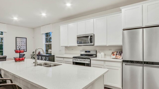 319 Snowdrop Ln, Elgin, IL 60124 - kitchen with appliances with stainless steel finishes, a sink, white cabinetry, a kitchen bar, and an island with sink