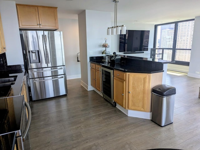 kitchen featuring appliances with stainless steel finishes, beverage cooler, dark wood-style flooring, and baseboards
