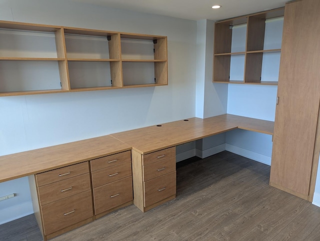unfurnished office with built in desk, dark wood-style flooring, recessed lighting, and baseboards