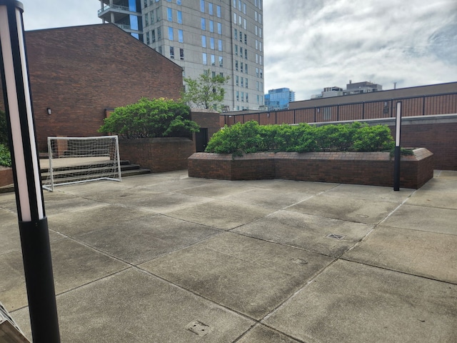 view of patio with a city view and fence
