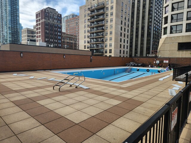 community pool with a view of city and a patio area