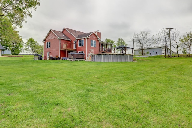 view of grassy yard featuring a jacuzzi and a gazebo