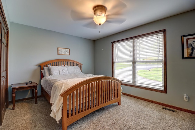 bedroom with light colored carpet, baseboards, and ceiling fan
