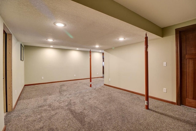 finished basement featuring a textured ceiling, carpet floors, baseboards, and recessed lighting