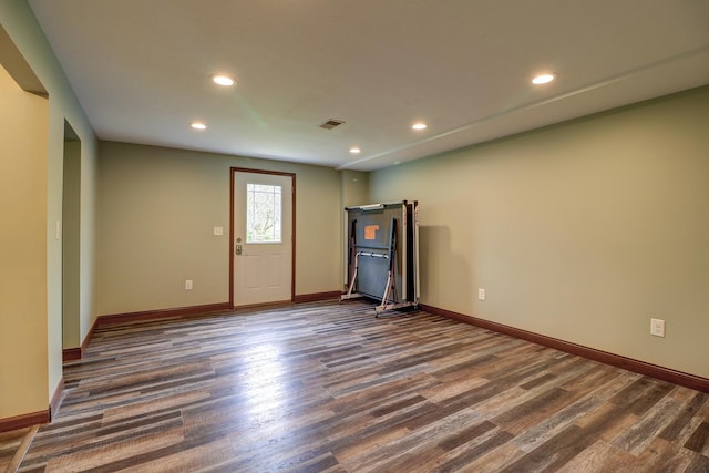 spare room with dark wood-style flooring, recessed lighting, and baseboards