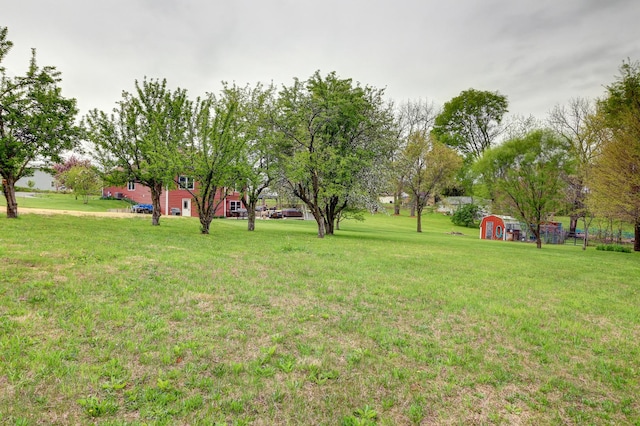 view of green lawn featuring a storage unit and an outdoor structure